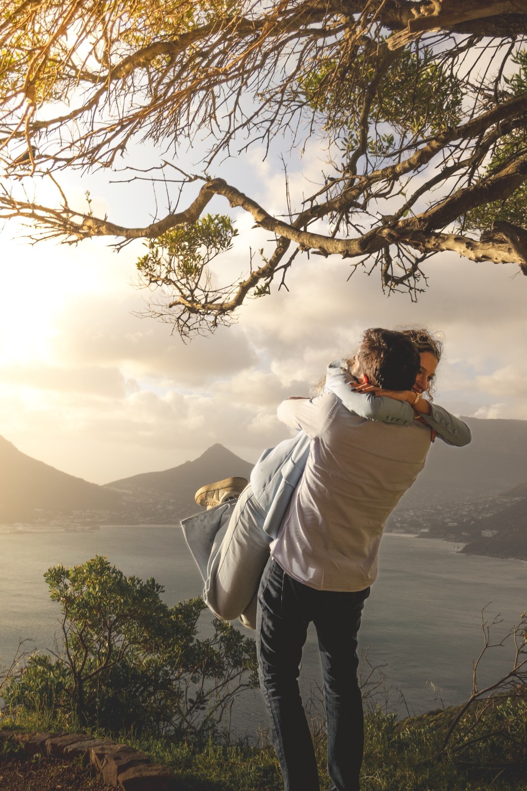 Man lifting his partner into an embrace after the proposal