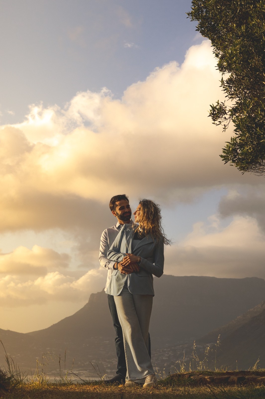 Engaged couple standing together against the mountain skyline