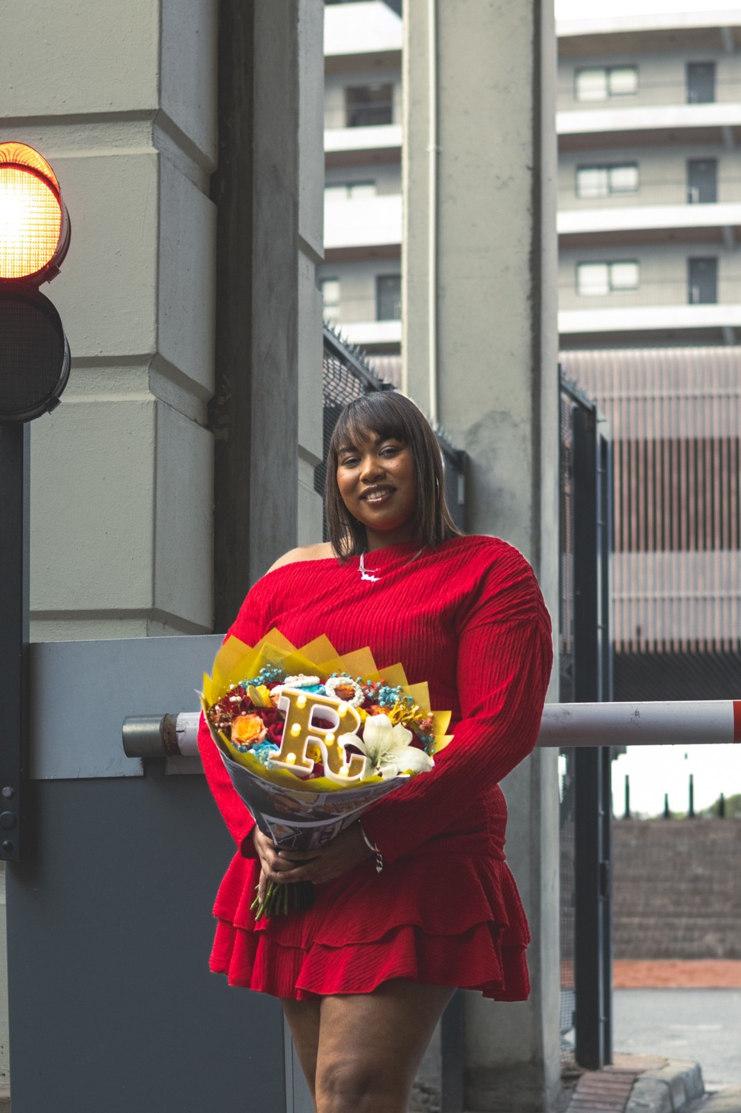 Woman with a colourful bouquet beside outdoor railings in Century City