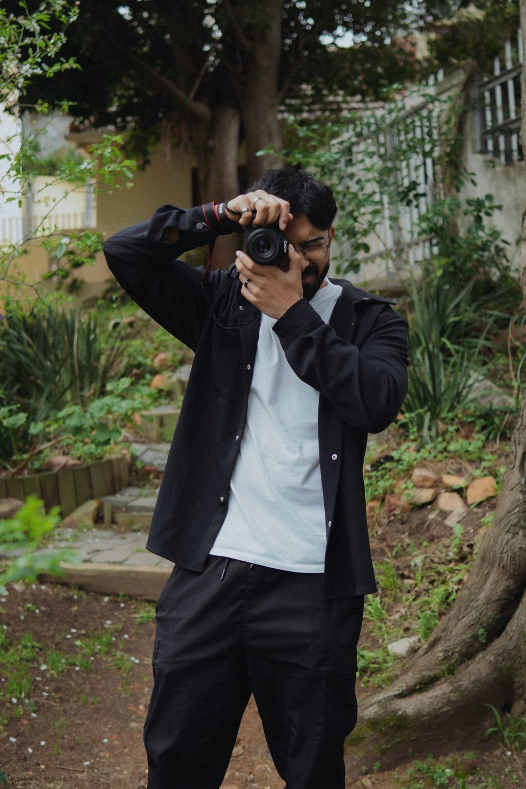 Levi photographing outdoors, camera raised, at Tremor Shots