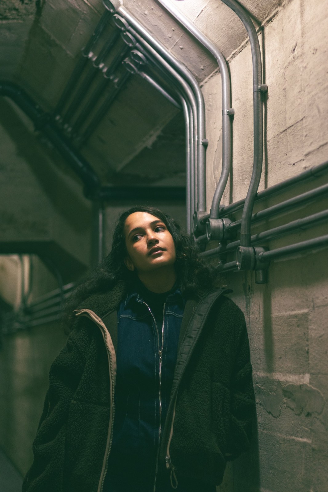 Woman framed by curved concrete and metal pipes inside Zeitz MOCAA